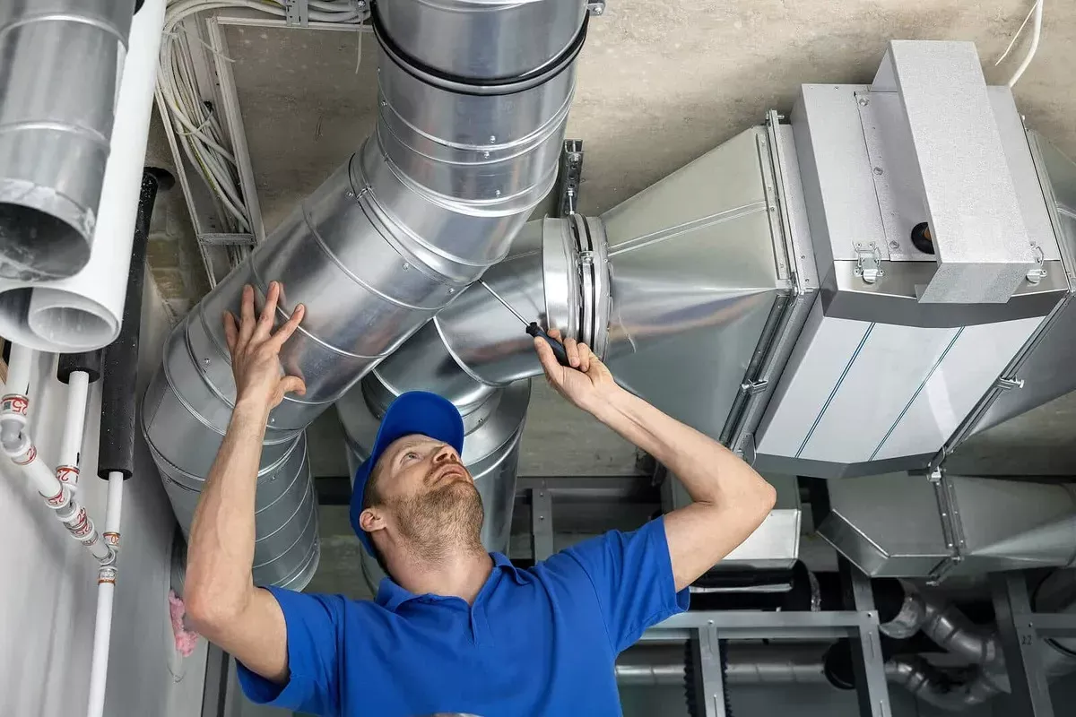 Technician performing AC duct cleaning inspection
