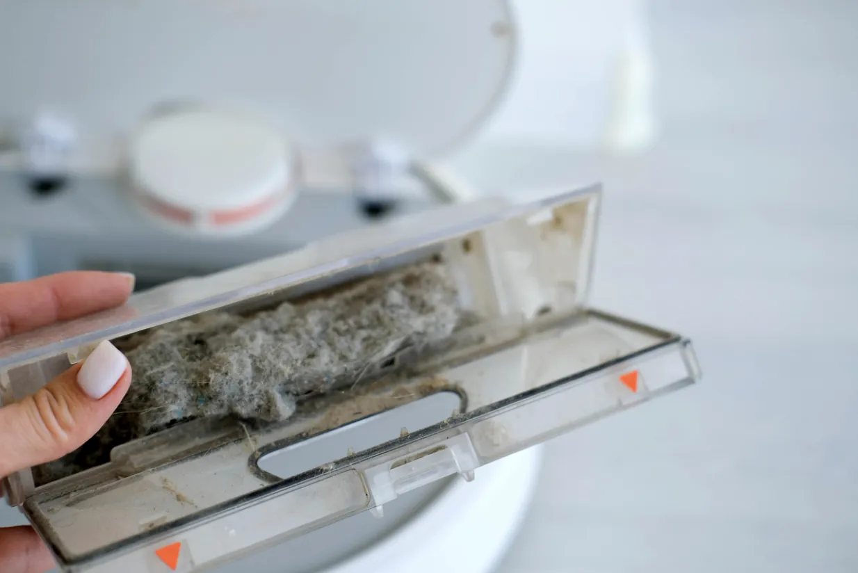 A close-up of a dust collection container filled with household debris and allergens removed during a professional home cleaning service in San Fernando.