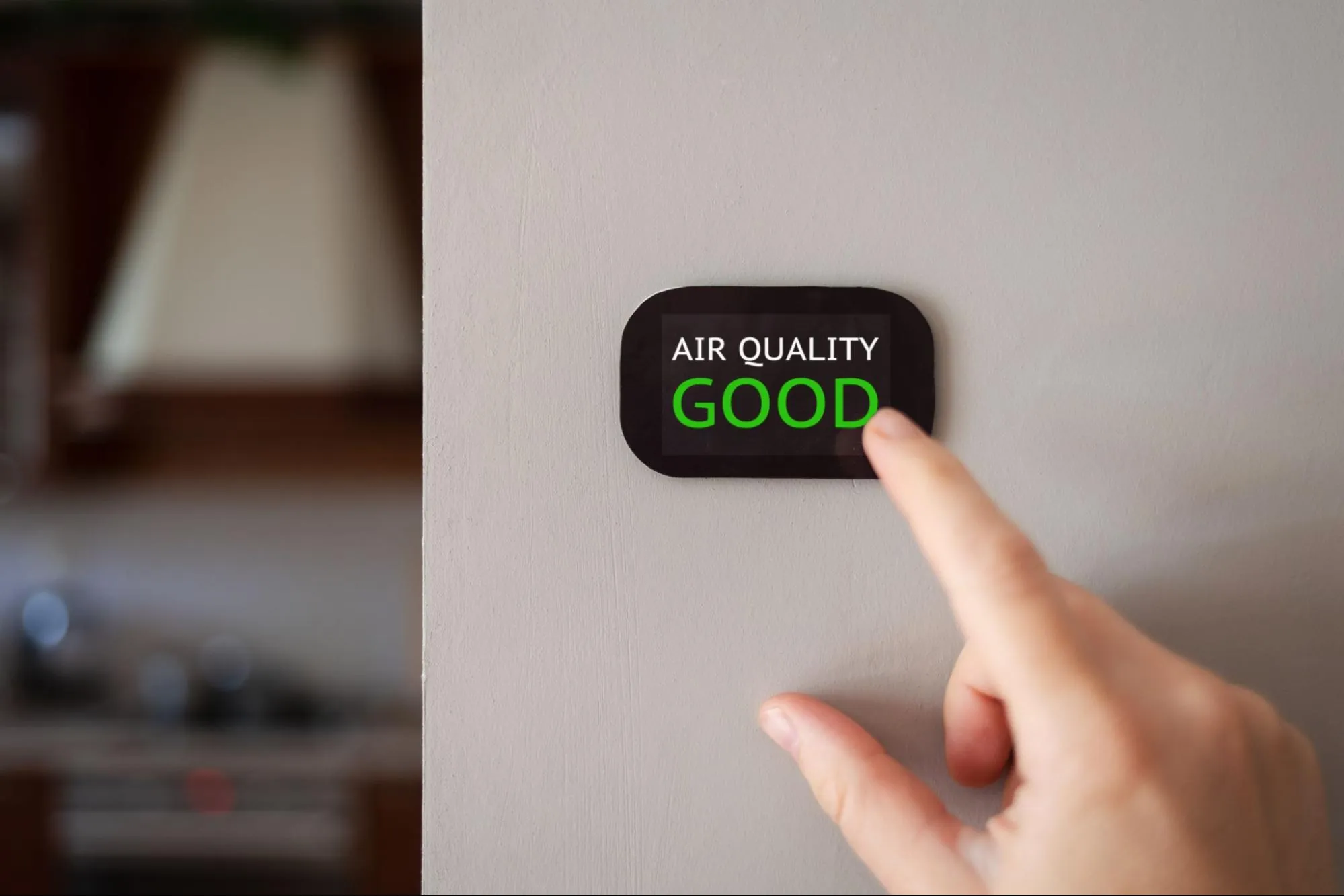 A modern digital air quality monitor on a residential wall in Los Angeles showing a 'Good' rating after professional testing and HVAC maintenance.