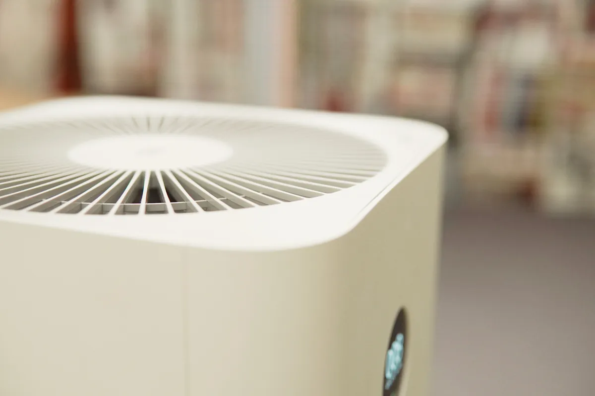 A modern, minimalist white air purifier with a digital blue light display, illustrating the clean air technology provided by SoCal Green Air and Chimney for Los Angeles homes.